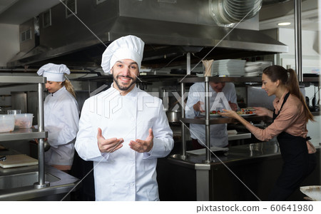 Chef in kitchen with busy staff Chef in kitchen with busy staff 60641980