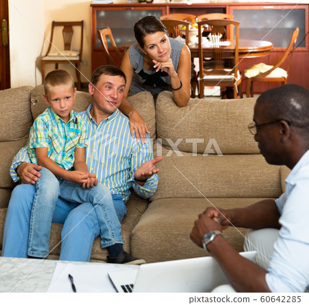 Social worker asks questions to parents of a child Social worker asks questions to parents of a child 60642285