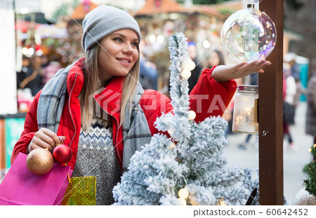 Happy girl chooses Christmas toys on the street market 60642452