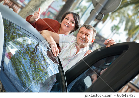 Adult couple sitting in twizy electric 60642455