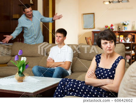 Disappointed woman with husband scolding teen son Disappointed woman with husband scolding teen son 60642602