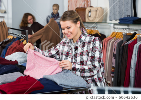 Woman choosing warm cardigan Woman choosing warm cardigan 60642636