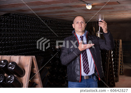 Winemaker proposing degustation of red wine Winemaker proposing degustation of red wine 60642827