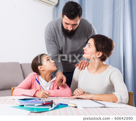 Parents helping daughter with homework 60642890