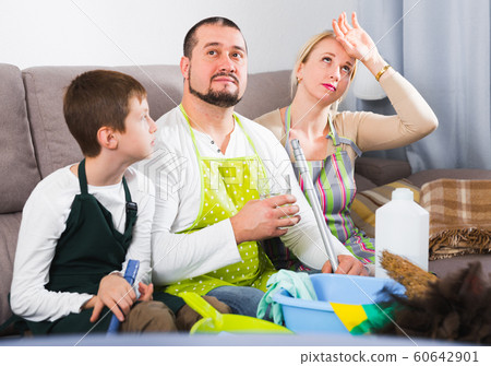 Tired parents with son dressed for cleaning 60642901