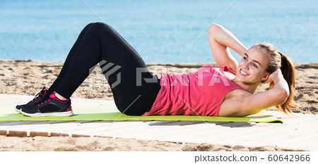 Woman doing yoga at beach Woman doing yoga at beach 60642966