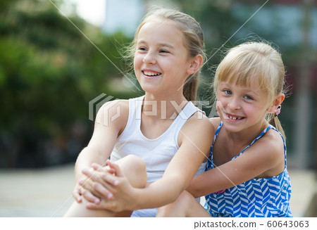 Two smiling little girls embracing Two smiling little girls embracing 60643063