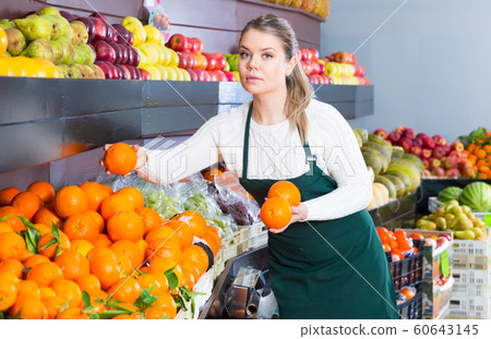 Positive woman selling fresh oranges and fruits Positive woman selling fresh oranges and fruits 60643145