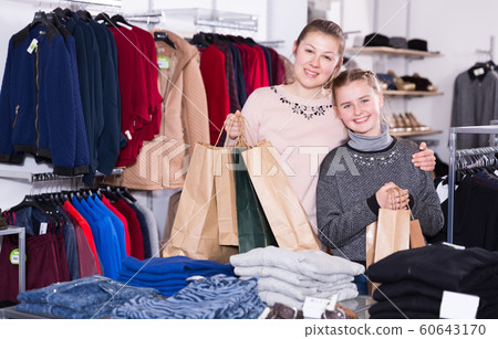 Woman with daughter with bags in clothing store Woman with daughter with bags in clothing store 60643170