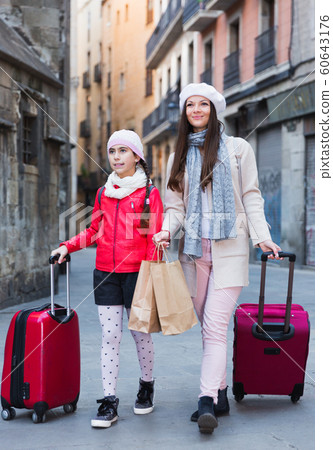 tourists girl and woman walking with baggage tourists girl and woman walking with baggage 60643176