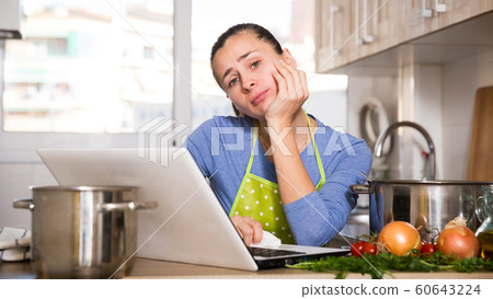 Frustrated woman looking for recipe 60643224