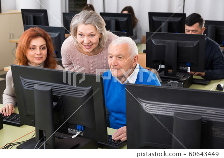 Students of different ages looking at monitor Students of different ages looking at monitor 60643449
