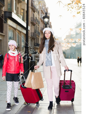 tourists girl and woman walking with baggage tourists girl and woman walking with baggage 60643524