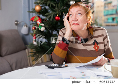 Mature woman calculates utility costs in the new year 60643532