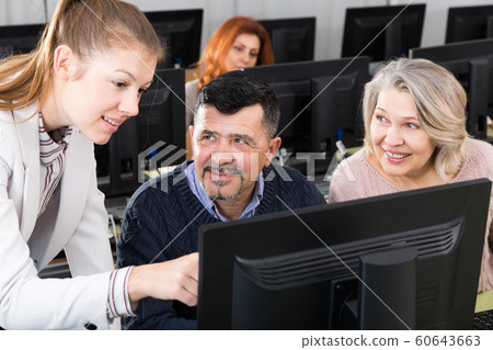 Business woman explaining something to coworkers, pointing at computer 60643663