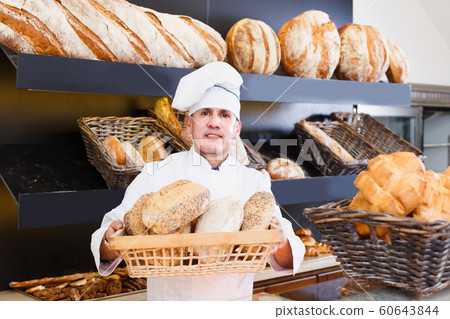 Baker man is showing tasty bread Baker man is showing tasty bread 60643844
