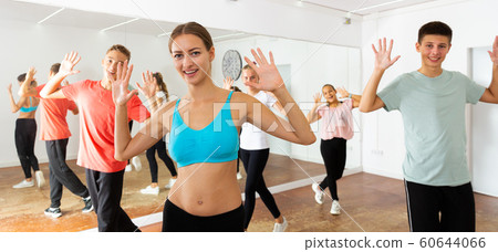 Female instructor fulfilling dance movements with teenagers Female instructor fulfilling dance movements with teenagers 60644066