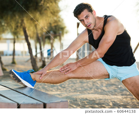 Male athlete stretching legs Male athlete stretching legs 60644138