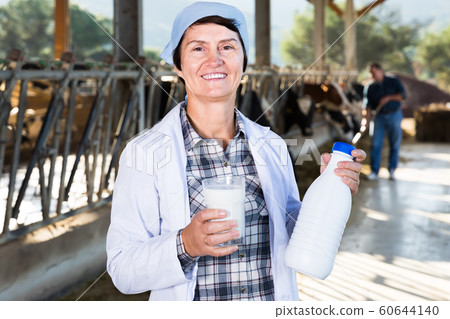 mature woman is standing at the cow farm mature woman is standing at the cow farm 60644140