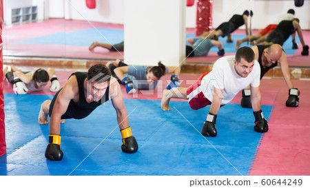 Group of men training together in hall Group of men training together in hall 60644249