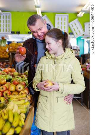 Portrait of father with daughter looking for ripe apples Portrait of father with daughter looking for ripe apples 60644409