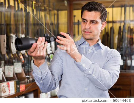 Cheerful man looking for optical sights Cheerful man looking for optical sights 60644468