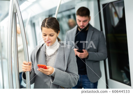 Young woman with phone in subway car Young woman with phone in subway car 60644533