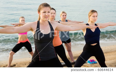 Positive sporty women practicing yoga positions 60644614
