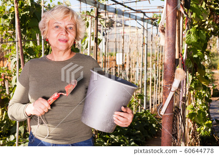 Woman with various garden accessories 60644778
