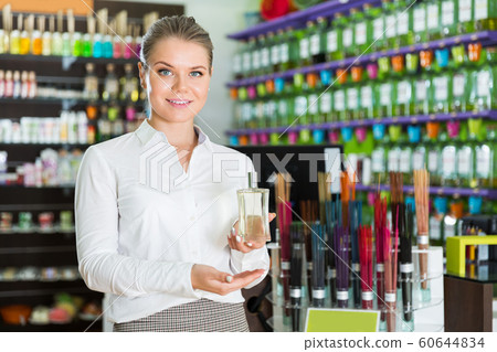 saleswoman offering new fragrance saleswoman offering new fragrance 60644834