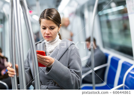 Young woman with phone in subway car Young woman with phone in subway car 60644861