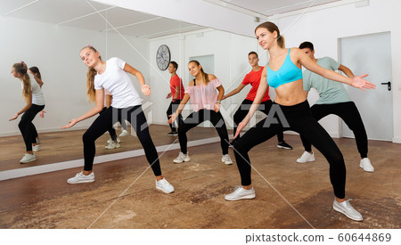 Teenagers exercising with coach in choreography class Teenagers exercising with coach in choreography class 60644869
