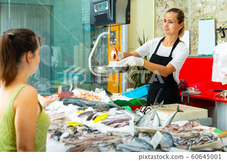 Positive female weighing raw prawns on scales Positive female weighing raw prawns on scales 60645001