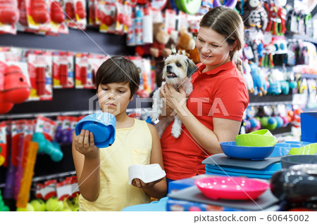 boy and his mother looking for supplies for little dog boy and his mother looking for supplies for little dog 60645002