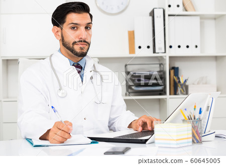 Doctor is working with documents in laptop Doctor is working with documents in laptop 60645005