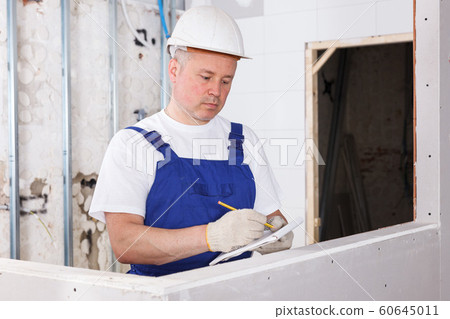 Construction worker inspecting room Construction worker inspecting room 60645011