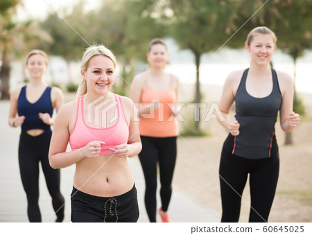 Happy young women during racewalking training Happy young women during racewalking training 60645025