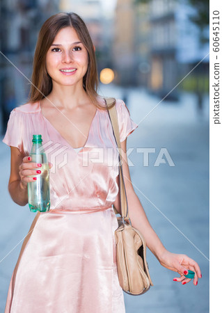 smiling adult girl drink water in the bottle smiling adult girl drink water in the bottle 60645110