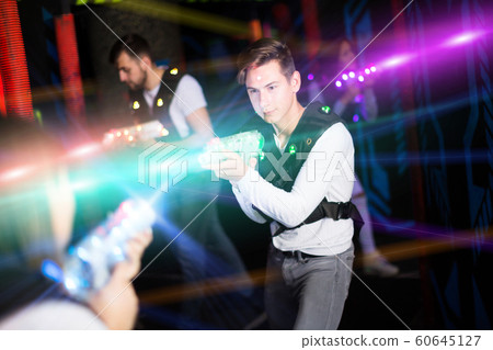 Excited guy laser tag player in bright beams Excited guy laser tag player in bright beams 60645127