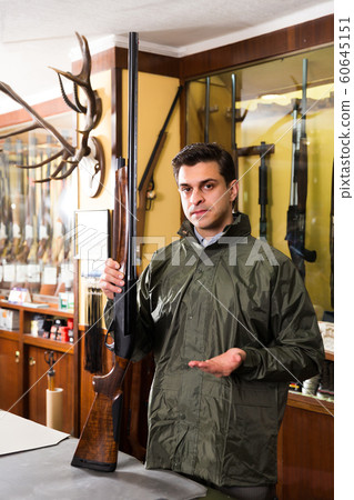 Portrait of positive confident man showing rifle Portrait of positive confident man showing rifle 60645151