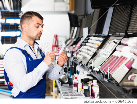 Professional car painter preparing paints for paintwork in modern auto repair shop Professional car painter preparing paints for paintwork in modern auto repair shop 60645162