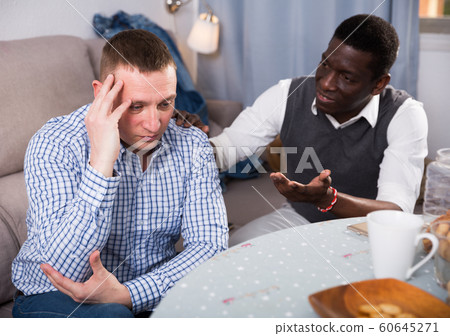African man soothing offended friend 60645271