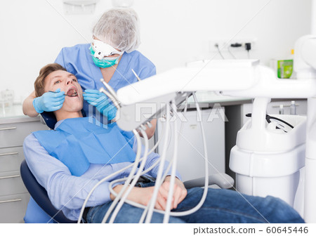 Young man on dental checkup in modern dentist office Young man on dental checkup in modern dentist office 60645446