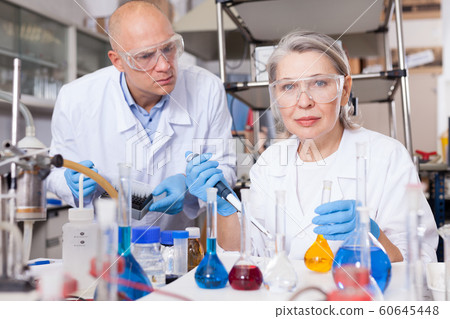 Chemists mixing reagents Chemists mixing reagents 60645448