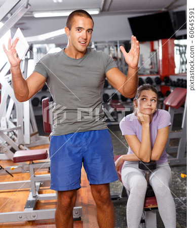 Coach and girl checking with workout plan 60645591