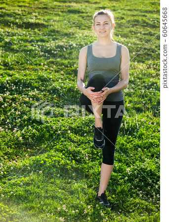 woman in sportwear doing exercises on mat in the garden woman in sportwear doing exercises on mat in the garden 60645668