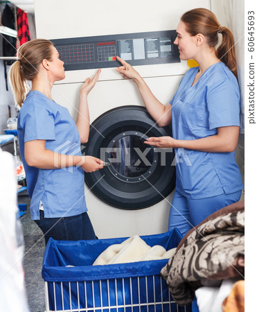 Two girls working in dry cleaning Two girls working in dry cleaning 60645693