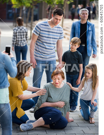 People helping sad grandmother with pain in heart People helping sad grandmother with pain in heart 60645705