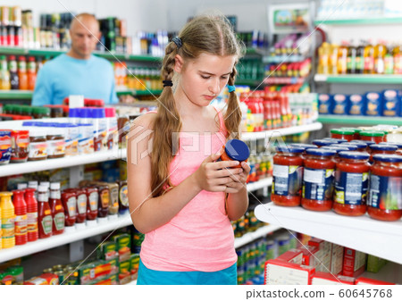 Tween girl choosing and buying food products at grocery shop 60645768