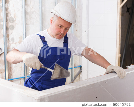 Builder filling gaps on drywall element 60645791